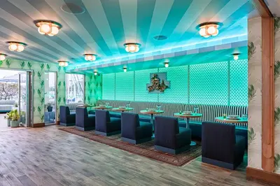 a restaurant with blue walls and tables and chairs at Marina del Rey Hotel in Los Angeles