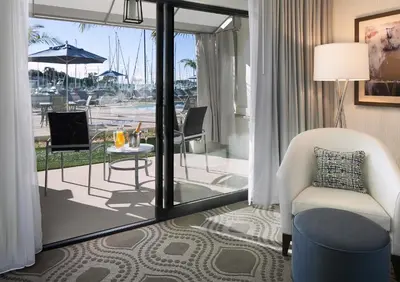 a living room with a white chair and a table at Marina del Rey Hotel in Los Angeles