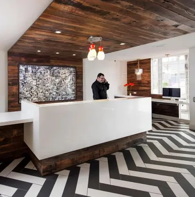 a man standing behind a reception desk in a lobby at Inn at Venice Beach in Los Angeles