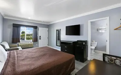 a hotel room with a bed and a bathroom at 3rd Avenue Inn in La Habra