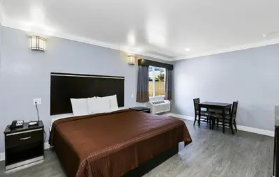 a hotel room with a bed and a table at 3rd Avenue Inn in La Habra