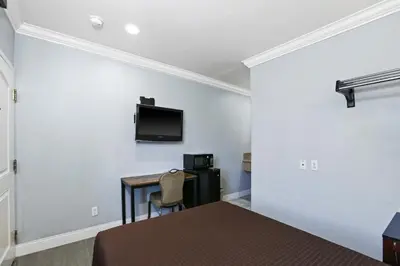 a room with a desk and a tv on the wall at 3rd Avenue Inn in La Habra