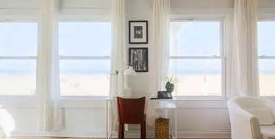 a living room with three windows and a desk at Su Casa at Venice Beach in Los Angeles