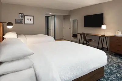 a hotel room with two beds and a desk at Four Points by Sheraton Bakersfield in Bakersfield