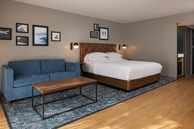 a bedroom with a bed and a blue couch at Four Points by Sheraton Bakersfield in Bakersfield