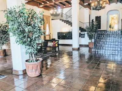 a large room with potted plants and stairs at Casa Bonita Apartments in Long Beach