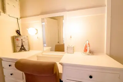 a room with a vanity with a mirror and a chair at Casa Bonita Apartments in Long Beach
