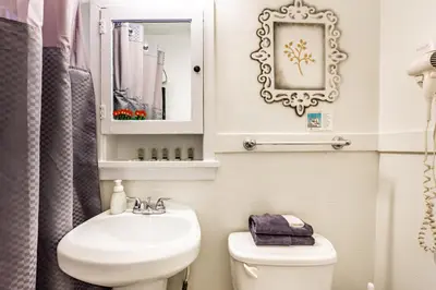 a bathroom with a sink and a toilet and a mirror at Casa Bonita Apartments in Long Beach