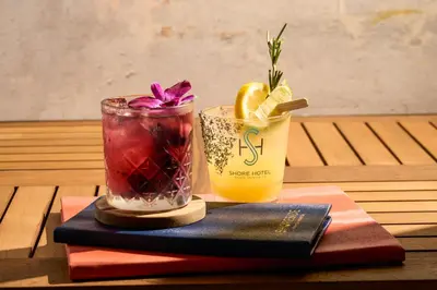 two cocktails and a book on a table at Shore Hotel in Los Angeles