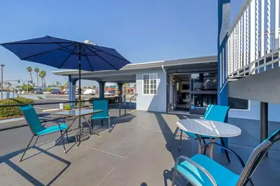a patio with tables and chairs and an umbrella at Best Western Orange Plaza in Orange