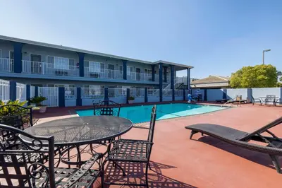 a patio with a table and chairs next to a pool at Best Western Orange Plaza in Orange