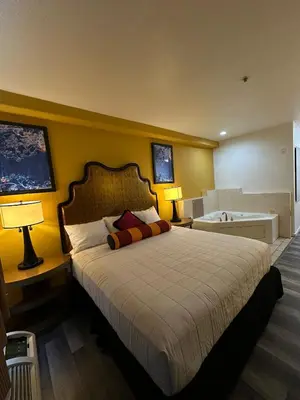 a bedroom with a bed and a bath tub in it at Howard Johnson by Wyndham Bakersfield in Bakersfield
