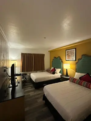 a hotel room with two beds and a television at Howard Johnson by Wyndham Bakersfield in Bakersfield