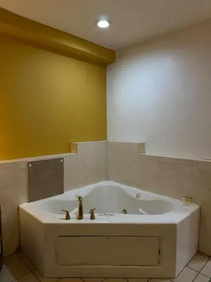 a large bath tub in a bathroom with yellow walls at Howard Johnson by Wyndham Bakersfield in Bakersfield