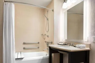 a bathroom with a sink and a tub and a shower at Sheraton Garden Grove-Anaheim South in Anaheim