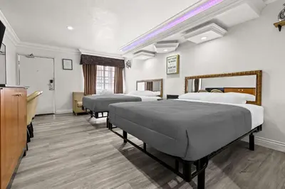 a room with three beds and a tv at Rodeway Inn Santa Ana - Garden Grove in Santa Ana