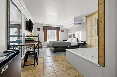 a hotel room with a bed and a bath tub at Rodeway Inn Santa Ana - Garden Grove in Santa Ana