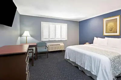 a hotel room with a bed and a desk at Days Inn by Wyndham West Covina in West Covina