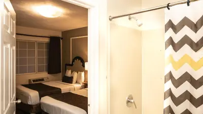 a hotel room with two beds and a shower at Americas Best Value Inn Rancho Palos Verdes in Rancho Palos Verdes