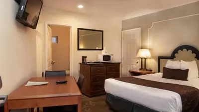 a hotel room with a bed and a desk and a television at Americas Best Value Inn Rancho Palos Verdes in Rancho Palos Verdes