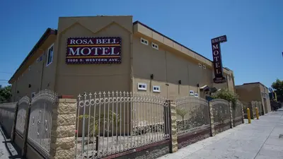 a building with a fence in front of a motel at Rosa Bell Motel - Los Angeles in Los Angeles