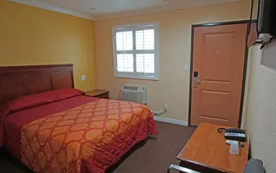 a bedroom with a bed and a table and a window at Rosa Bell Motel - Los Angeles in Los Angeles