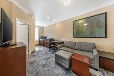a living room with a couch and a desk at Best Western PLUS Avita Suites in Torrance