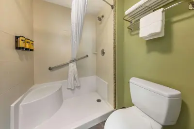 a bathroom with a white tub and a toilet at Best Western PLUS Avita Suites in Torrance
