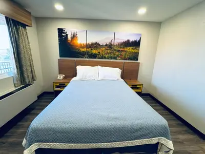 a bedroom with a bed and a painting on the wall at Days Inn by Wyndham Barstow in Barstow