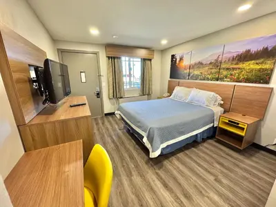 a hotel room with a bed and a flat screen tv at Days Inn by Wyndham Barstow in Barstow