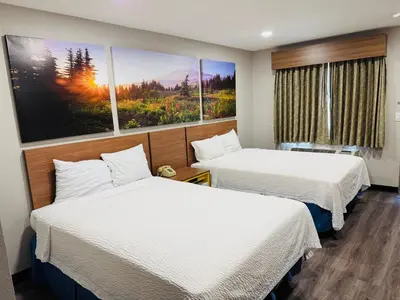 a hotel room with two beds and a painting on the wall at Days Inn by Wyndham Barstow in Barstow