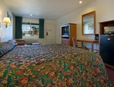 a bedroom with a large bed in a hotel room at Orange Show Inn in San Bernardino