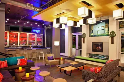 a lobby with a bar with couches and chairs at Aloft Ontario-Rancho Cucamonga in Rancho Cucamonga