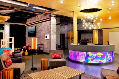 a lobby with chairs and a table and a bar at Aloft Ontario-Rancho Cucamonga in Rancho Cucamonga