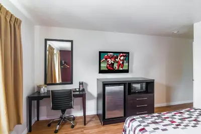 a bedroom with a desk and a bed and a chair at Red Roof Inn Palmdale - Lancaster in Palmdale