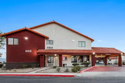 a red and white building on a street at Red Roof Inn Palmdale - Lancaster in Palmdale