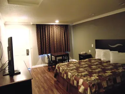 a hotel room with a bed and a desk at West Coast Inn Santa Ana in Santa Ana