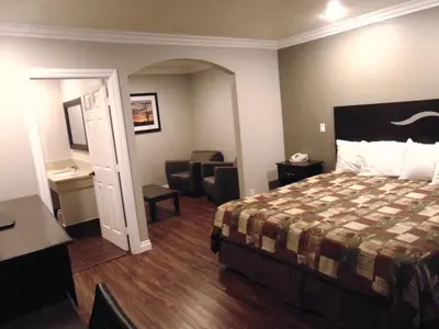 a hotel room with a bed and a chair at West Coast Inn Santa Ana in Santa Ana