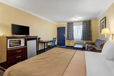 a hotel room with a bed and a living room at Quality Inn - Torrance Lomita in Lomita