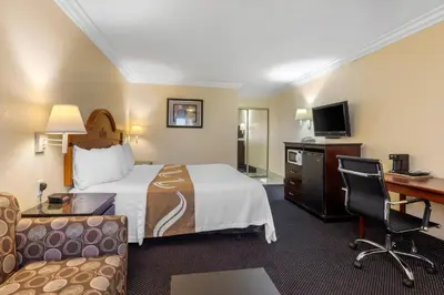 a hotel room with a bed and a desk and a computer at Quality Inn - Torrance Lomita in Lomita