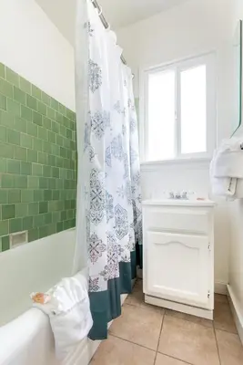 a bathroom with a tub and a shower curtain at Wilshire Motel in Los Angeles