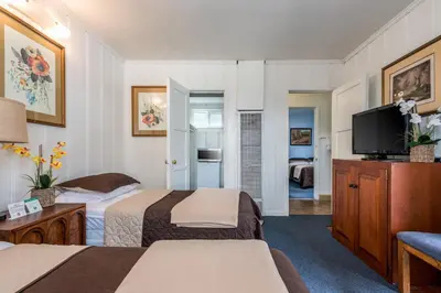 a hotel room with two beds and a flat screen tv at Wilshire Motel in Los Angeles