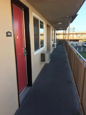 a hallway of a building with a red door at Budget Inn LAX-Lawndale in Lawndale