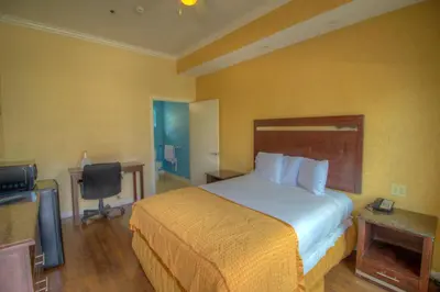 a hotel room with a bed and a flat screen tv at Princess Inn in Westminster