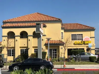 a black car parked in front of a restaurant at Cali Inn in Carson