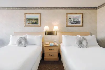 two beds in a hotel room with white pillows at Glendale Express Hotel Los Angeles in Glendale