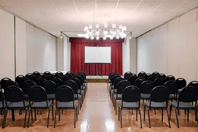 a conference room with chairs and a screen at Glendale Express Hotel Los Angeles in Glendale