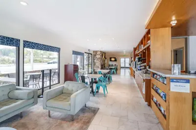 a lobby with chairs and a table and a kitchen at Best Western At Ventura Pier in Ventura