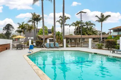 a pool at a resort with palm trees at Best Western At Ventura Pier in Ventura