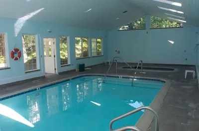 a large indoor swimming pool with blue water at Giant Oaks Lodge in Running Springs